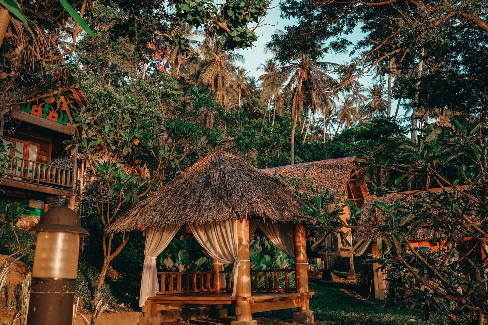 Bungalows en bambou et toits de chaume sous les palmiers